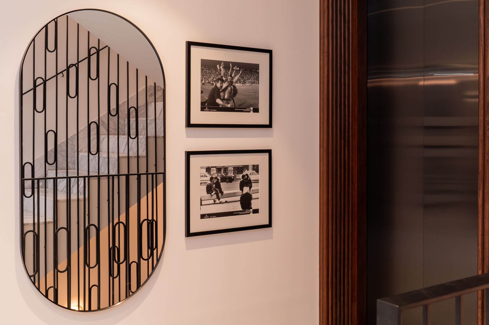 Hallway with oval mirror and black and white photographs at Casa Roca in Palma