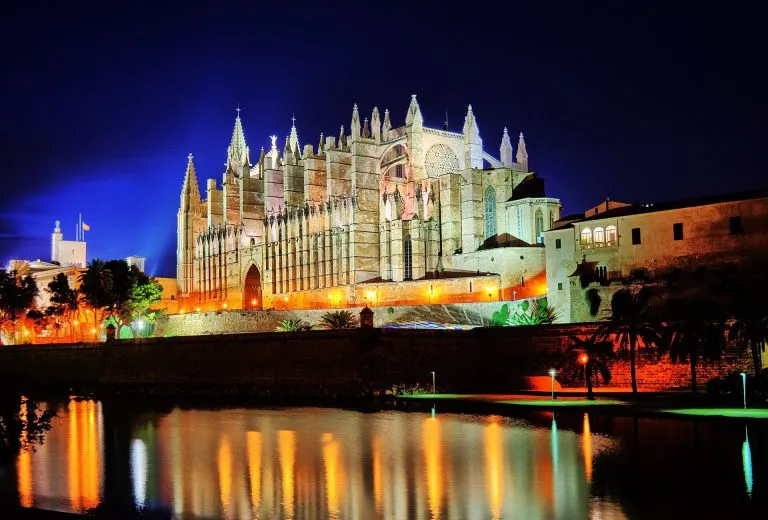 Palma Cathedral, La Seu, floodlit at night and reflected in the Parc de la Mar lake