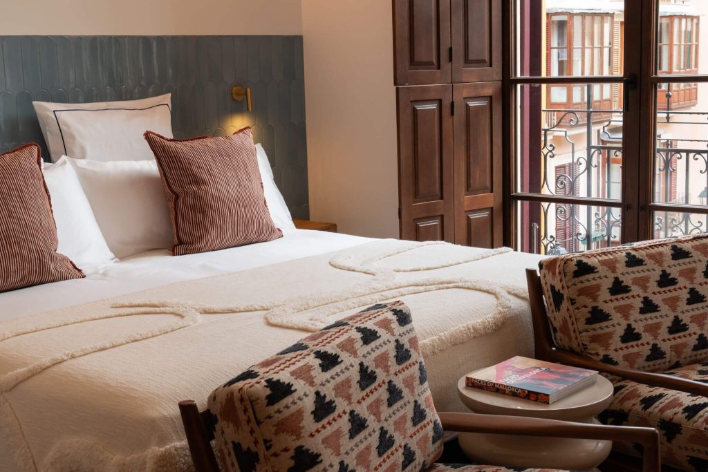 Luxury Suite bed with patterned armchairs at Casa Roca