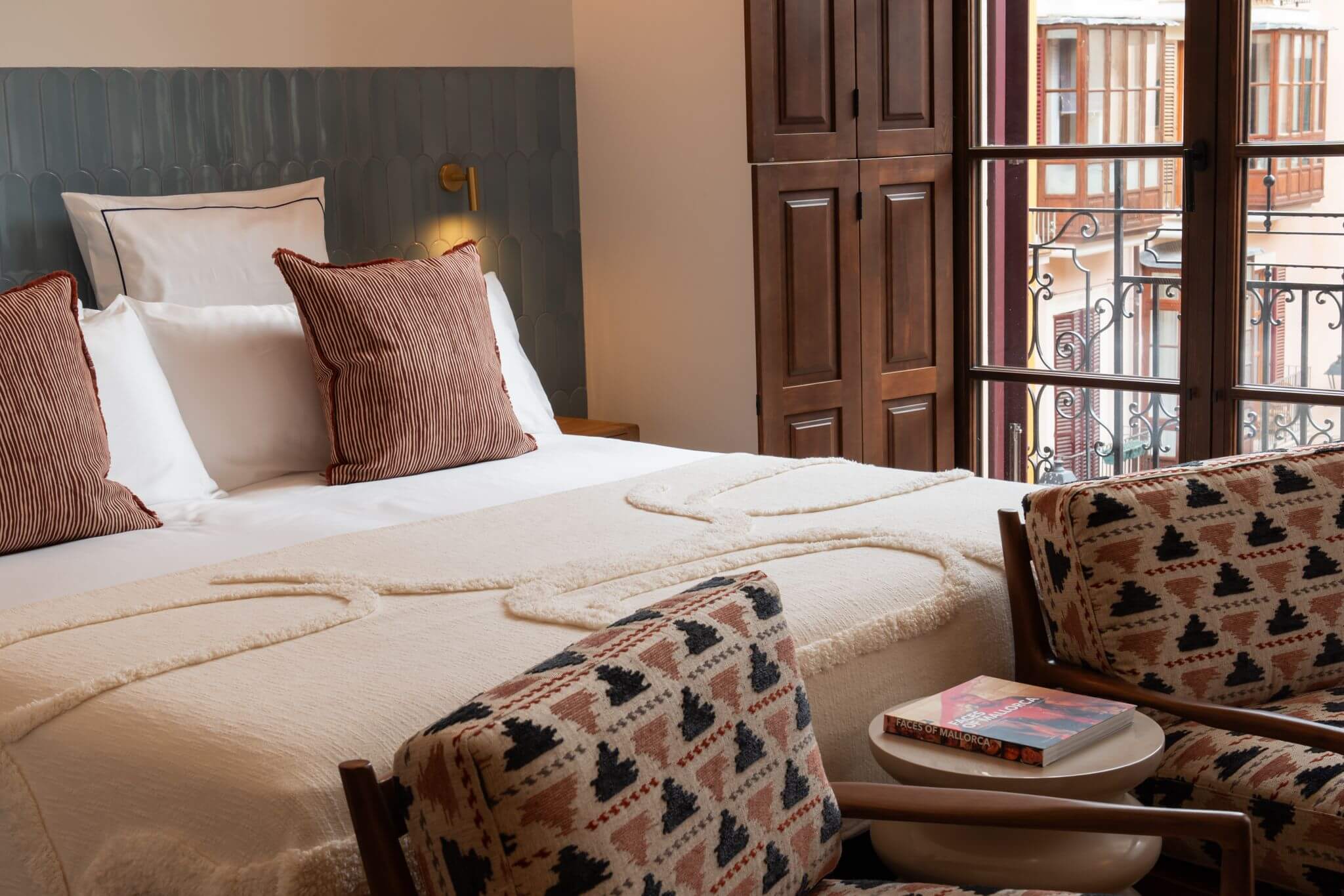 Luxury Suite bed with patterned armchairs at Casa Roca in Palma