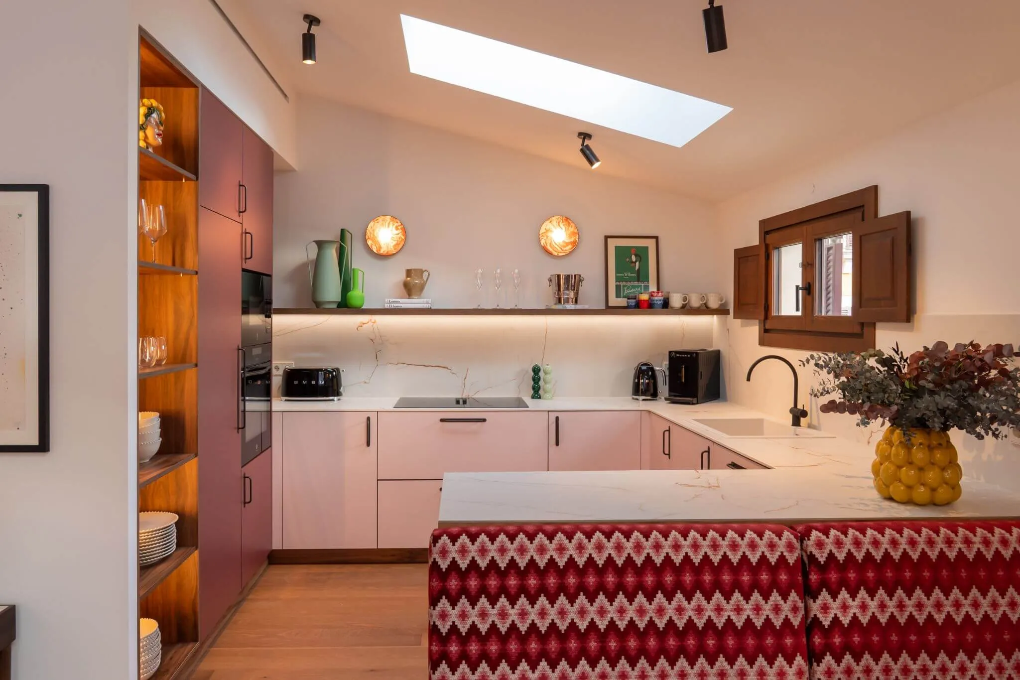 Penthouse kitchen with red tiled island at Casa Roca in Palma Old Town