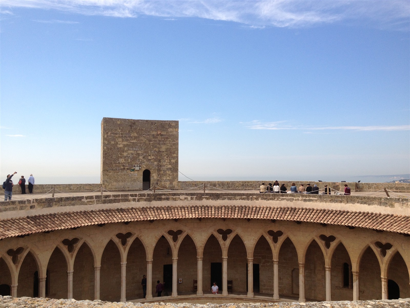 Visitors on the roof terrace of Bellver Castle with the keep tower behind