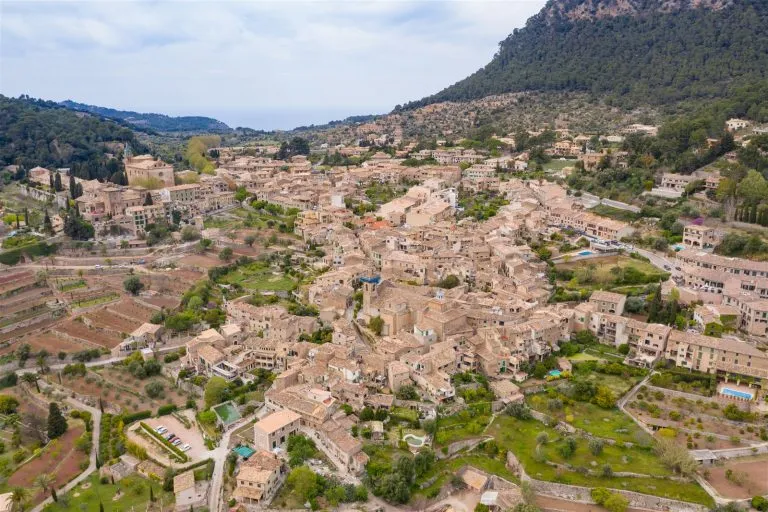 Aerial view of Valldemossa village and its stone houses below the Serra de Tramuntana