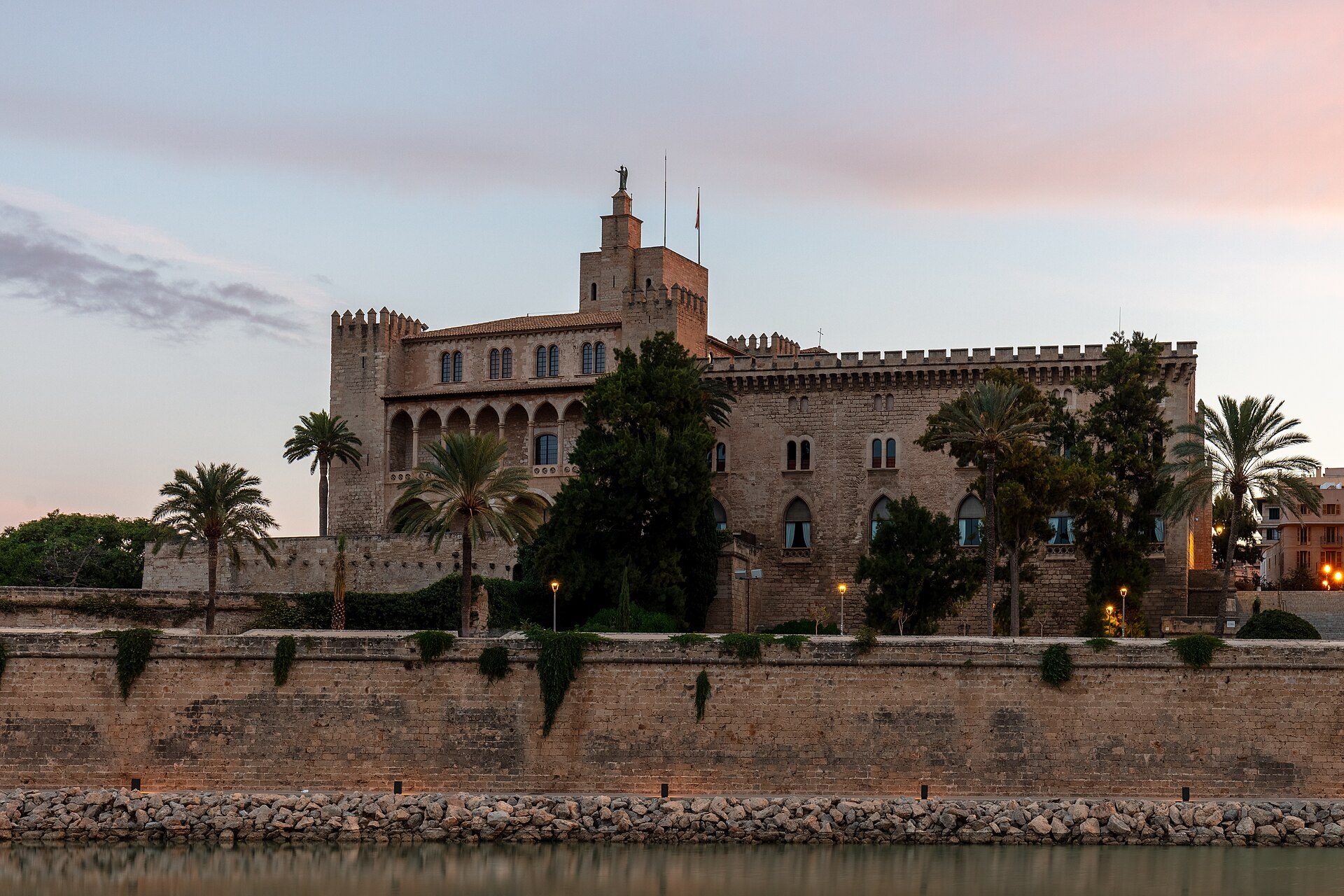 Royal Palace of La Almudaina in Palma at dusk above the Parc de la Mar walls